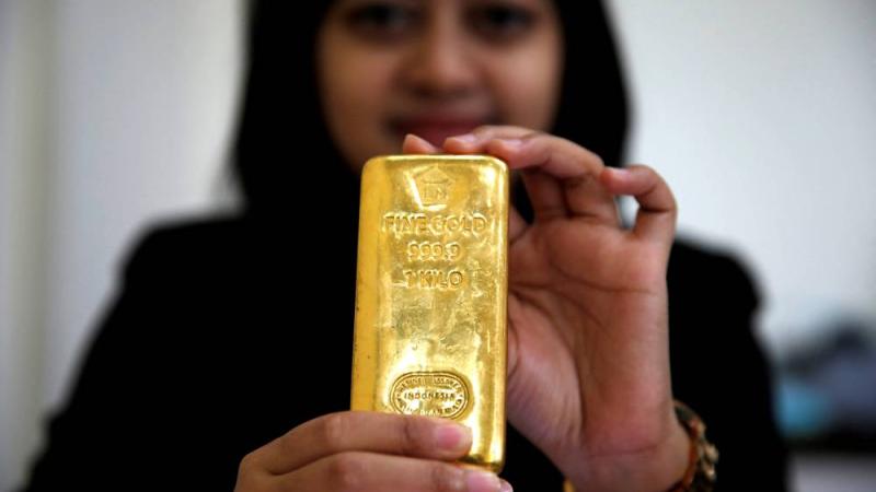 موظفة  تحمل سبيكة من الذهب بشركة للمجوهرات في جاكرتا، إندونيسيا (رويترز)